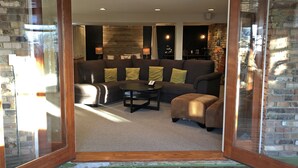 Un salón acogedor con un sofá seccional, una mesa de centro y una chimenea.