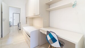 A modern, minimalist room with a built-in desk, a chair, and a wardrobe. - HouSmart San Carlo 17 (Bologna)