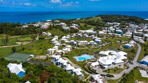 Vista aérea de un resort con varias construcciones, una piscina y un campo de golf.