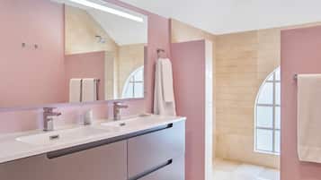 Un baño moderno con dos lavamanos, un espejo grande y una ventana.