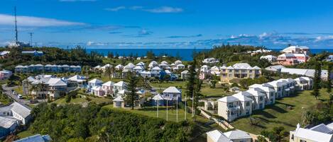 A coastal residential area with multiple houses, some with balconies, and a clear view of the sea.