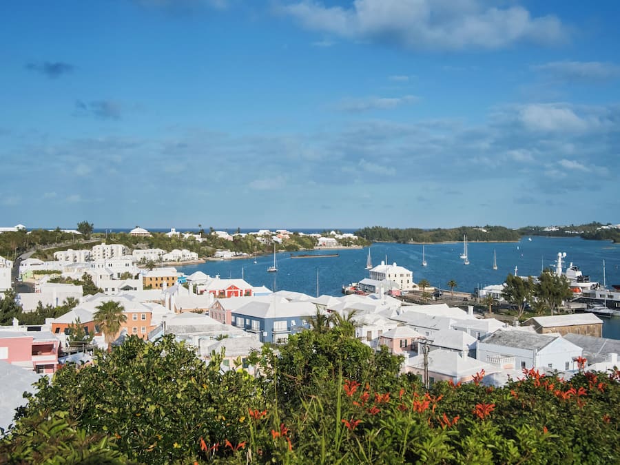 A coastal town with buildings along the waterfront, boats in the water, and a clear sky.