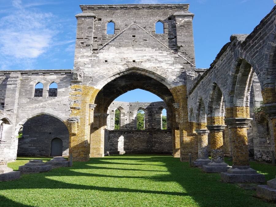 Una estructura antigua de piedra con arcos y una torre central.