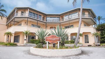 A multi-story hotel with a sign reading "St George's Club Hotel" surrounded by palm trees and a landscaped area.