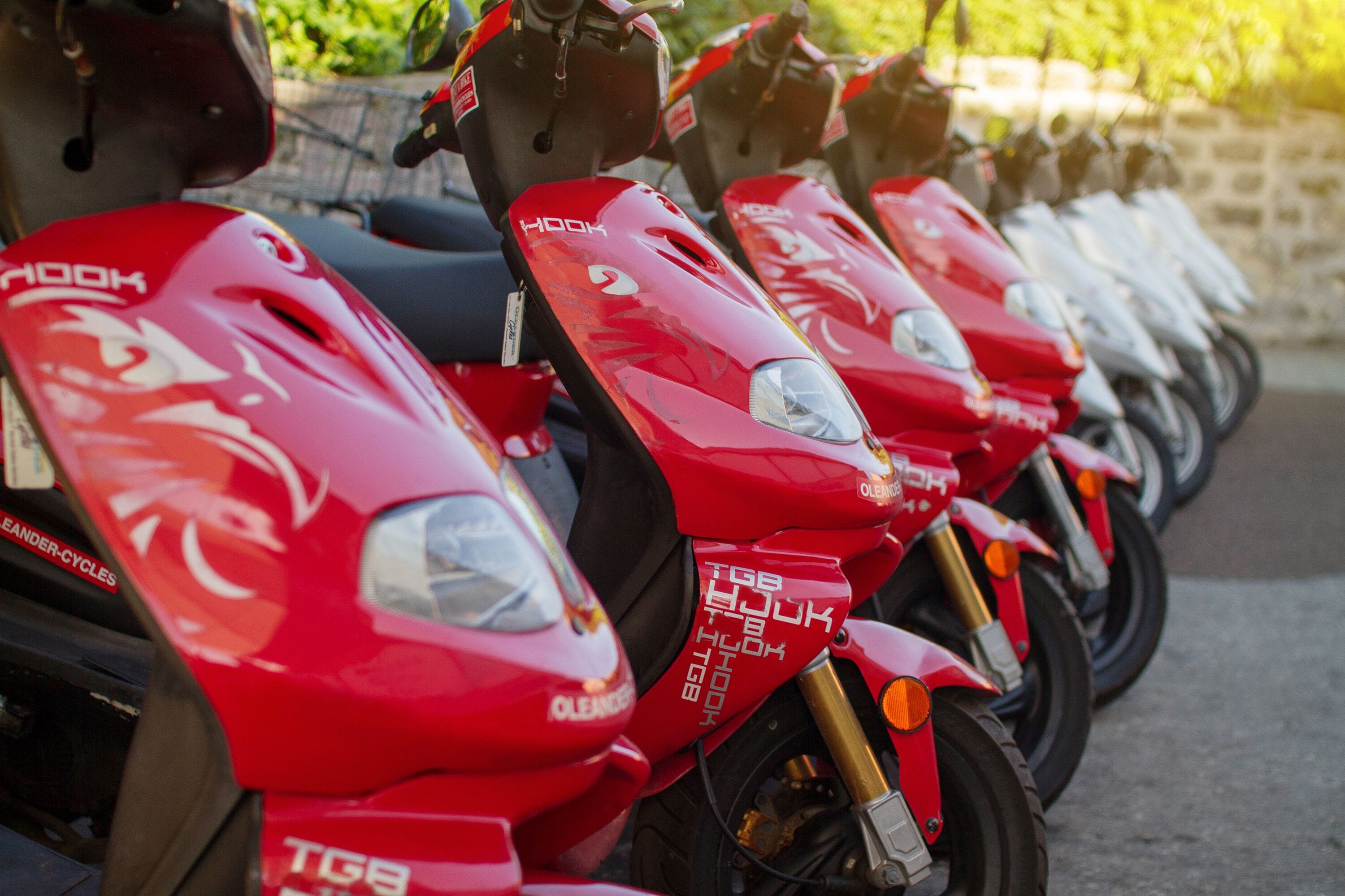 A row of red scooters parked in a line.