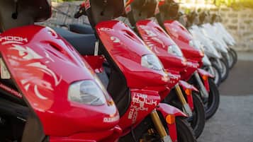 A row of red scooters parked in a line.