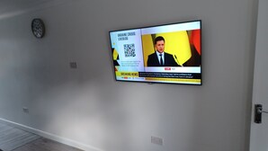 Un téléviseur fixé au mur diffusant un journal télévisé.