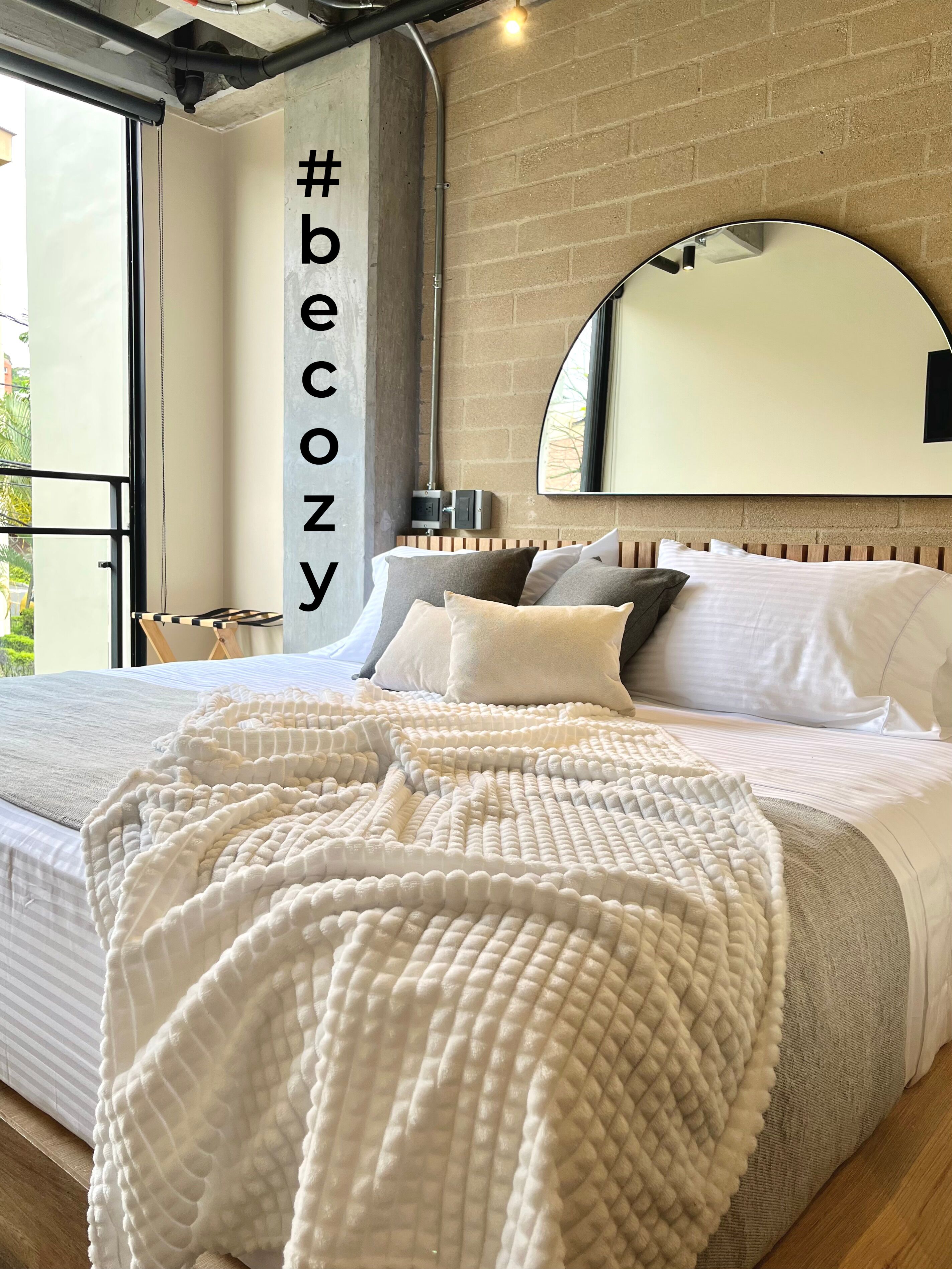 Een slaapkamer met een groot bed, een spiegel en uitzicht op het landschap.