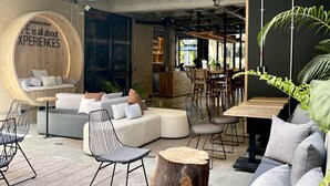 Un área de estar al aire libre moderna con un sofá, sillas y una mesa de madera.