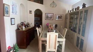A dining area with a glass-top table, wooden chairs, a red carpet, and a cabinet with glass doors. - Three bedrooms, full kitchen, clean, quiet and relaxing. (St. Cloud)