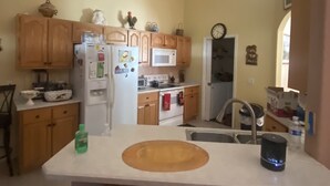 A kitchen with wooden cabinets, a white countertop, a sink, and a stove. - Three bedrooms, full kitchen, clean, quiet and relaxing. (St. Cloud)