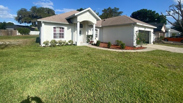 A single-story house with a front porch, a garage, and a well-maintained lawn. - Three bedrooms, full kitchen, clean, quiet and relaxing. (St. Cloud)