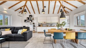 Een modern interieur met een zithoek, eethoek en keuken.