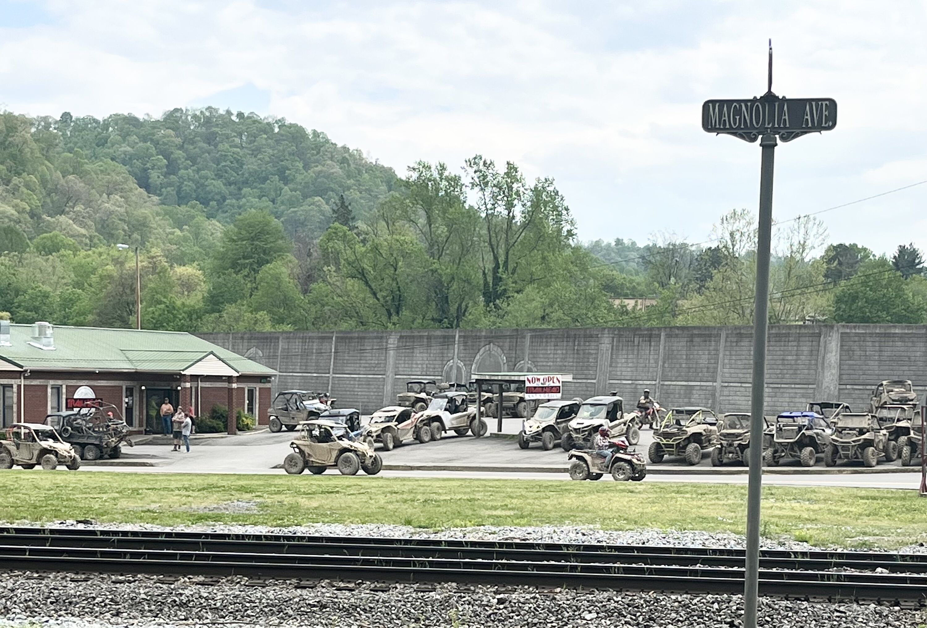 A parking area with ATVs and a building with a green roof.