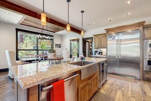 Enjoy cooking in this well-lit kitchen with a large island, oven, and stainless steel sink.
