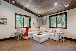 Relax in this stylish living room with a large L-shaped sofa, matching ottoman, and a cozy throw blanket.