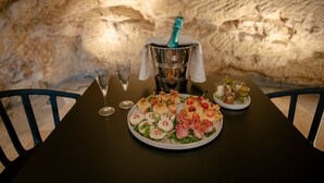 Una mesa dispuesta con diversos aperitivos, una botella de champán y dos copas de vino.