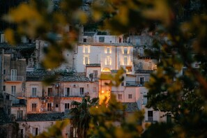 A row of buildings with balconies, some with railings, and a few with visible windows. - Ibla Rooms (Ragusa)