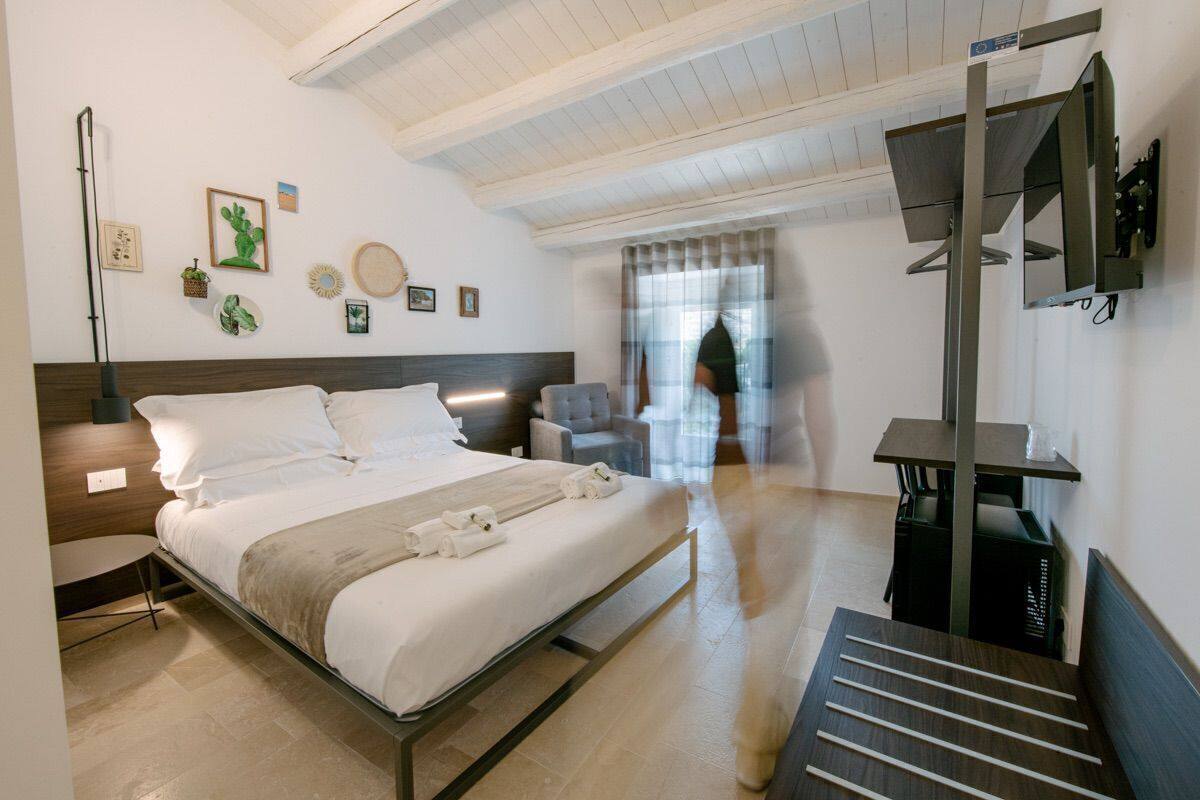 Ein Schlafzimmer mit einem Bett, Nachttischen, einem Schreibtisch und einem Spiegel.