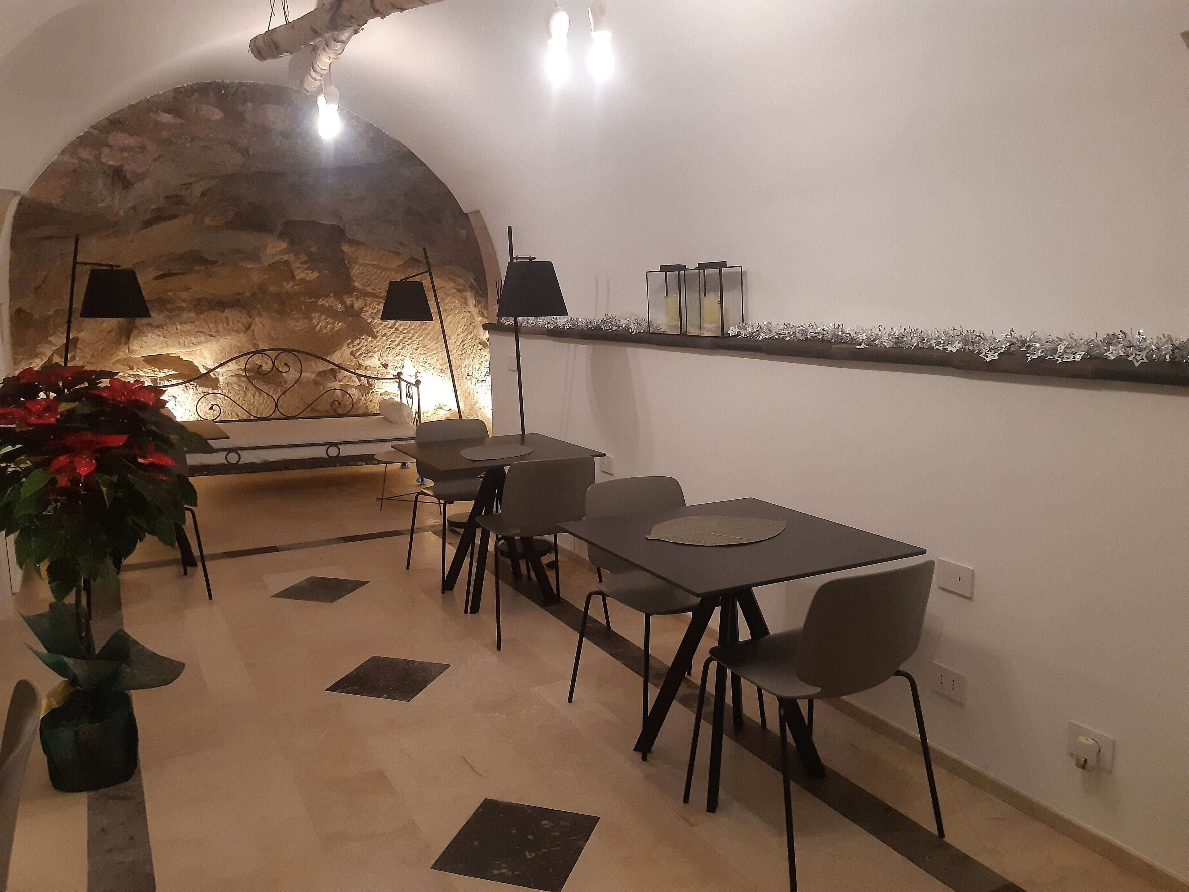A dining area with a stone wall, a table with chairs, and a potted plant.