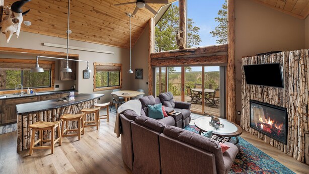 A spacious living area with a large sofa, a fireplace, and a dining area.