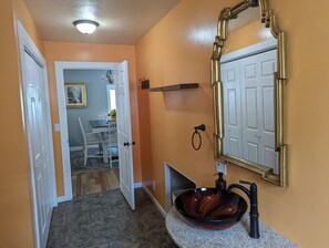 A bathroom with a vanity, a sink, and a mirror.