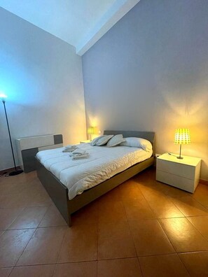 Ein Schlafzimmer mit einem Bett, Nachttischen und Lampen.