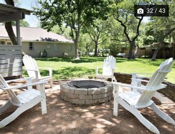 Relax in the serene outdoor seating area with a fire pit and Adirondack chairs.