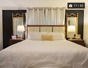 Classic hotel room with a large bed, two nightstands, and a simple design.