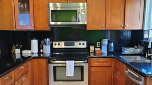 A kitchen with wooden cabinets, stainless steel appliances, a microwave, oven, and a dishwasher.