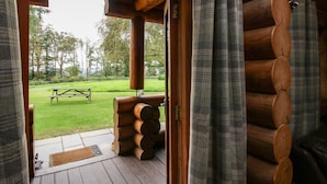 A log cabin interior with a wooden door leading to a patio area. - Brynallt Country Park (Ellesmere)