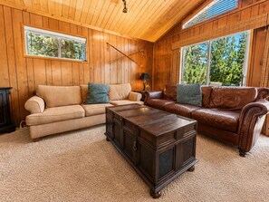 A wooden-paneled room with two sofas, a coffee table, and a lamp. - Cub Run Cabin -6 Bedroom, Walk to Lake/Village, Hot Tub, Foosball (Big Bear Lake)