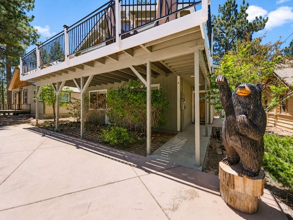 A two-story building with a covered porch and a wooden deck.