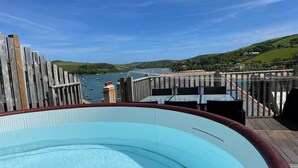 Ein Pool mit Blick auf eine Küstenlandschaft, darunter ein Gewässer und Hügel.