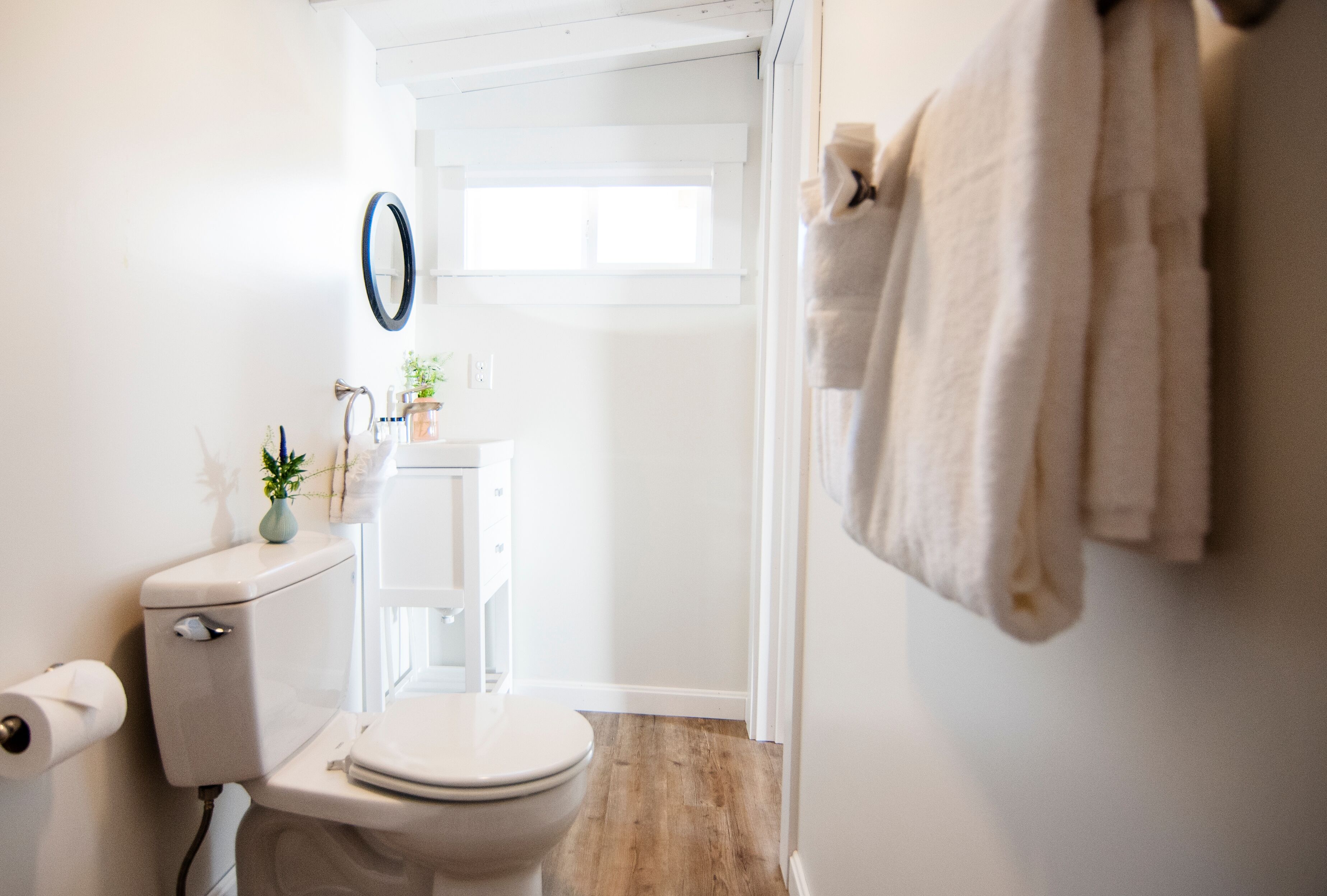 A bathroom with a toilet, sink, and towel rack.