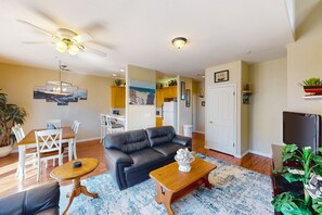 Relax in this open-plan living area with a sofa, dining table, and kitchen.