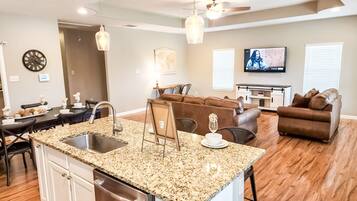 A modern kitchen with granite countertops, stainless steel appliances, and a dining area with a table and chairs.