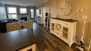 Un amplio espacio de estar con mesa de comedor, un reloj grande y una chimenea.