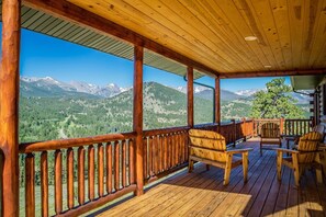 Una terraza de madera con vista a un paisaje montañoso.