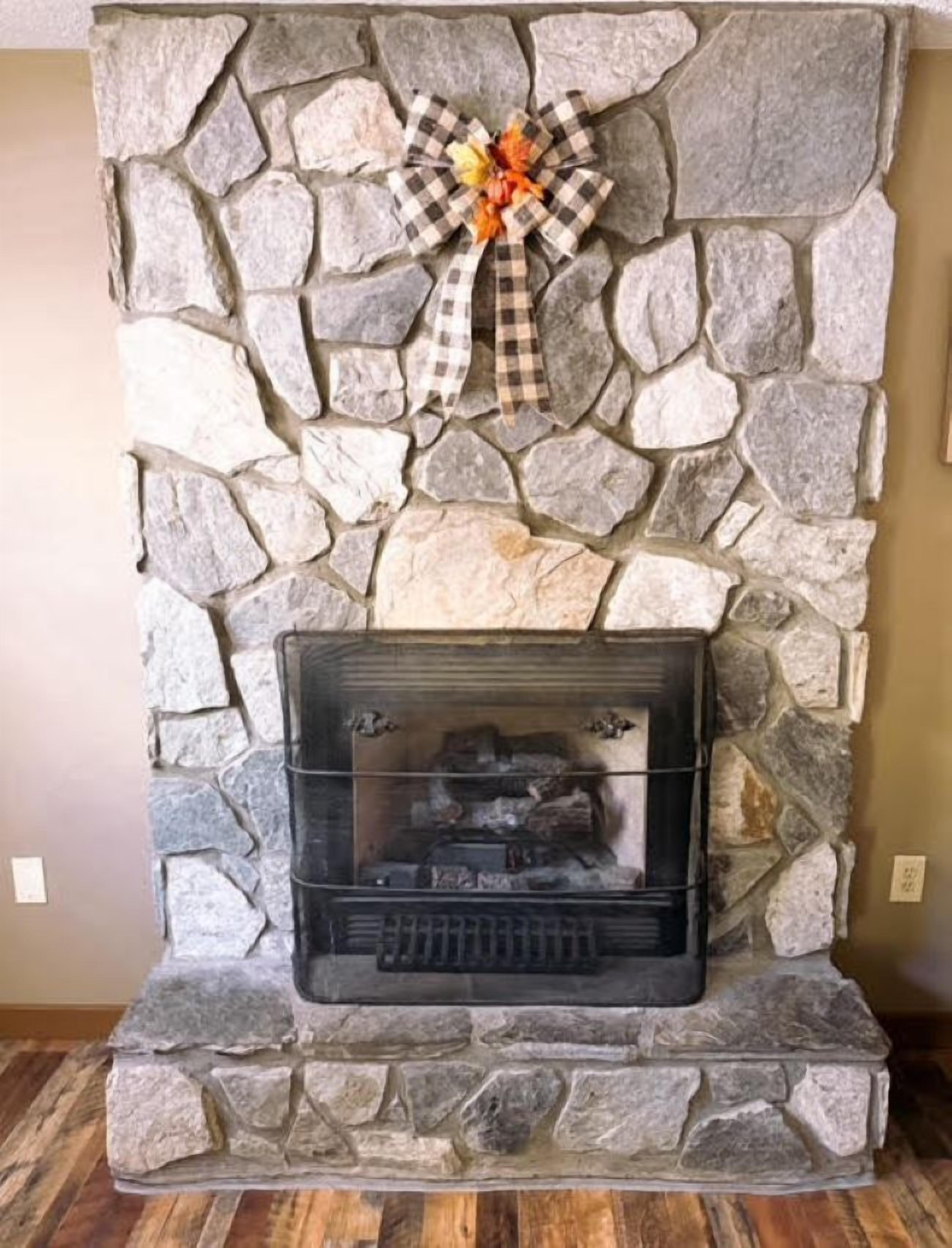 A stone fireplace with a checkered bow decoration.
