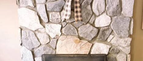 A stone fireplace with a checkered bow decoration.