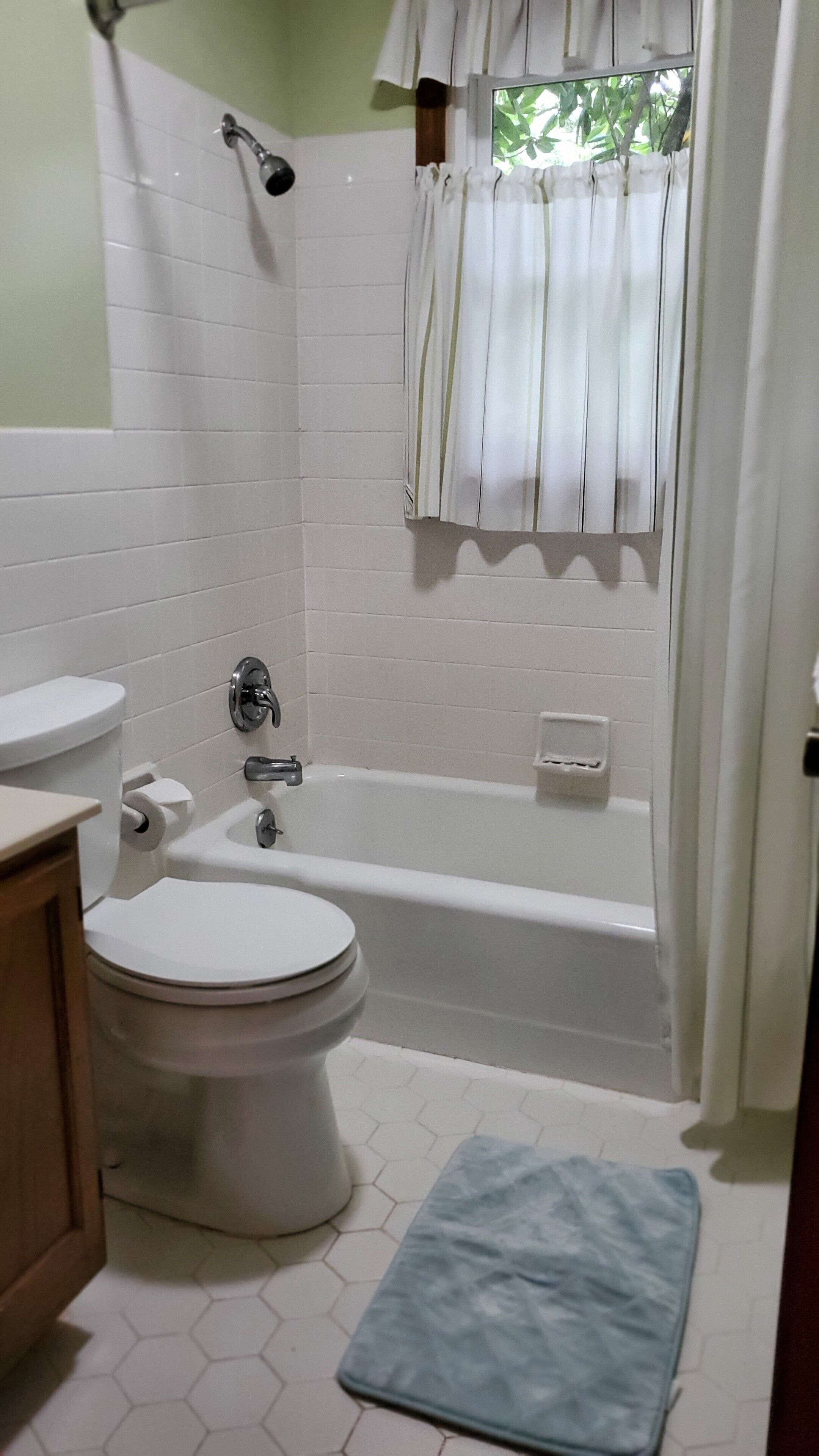 A bathroom with a toilet, sink, bathtub, and shower.