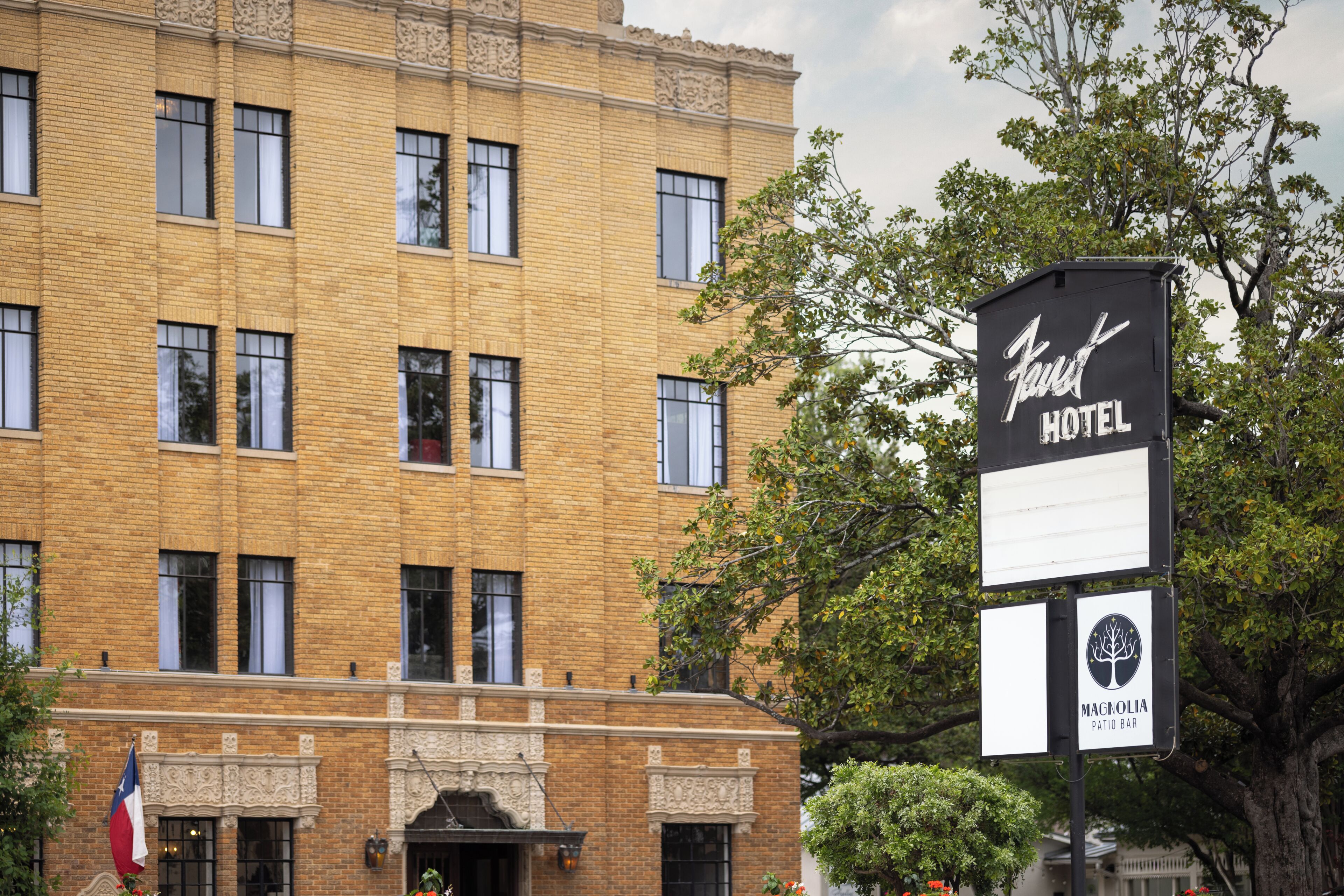 A hotel sign with 'Vast Hotel' and 'Magnolia Patio Bar' visible.