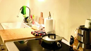 A compact kitchen with a stove, sink, and a coffee maker. - Eurovision Song Contest downtown Turin (Torino)