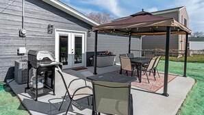 An outdoor patio with a grill, seating area, and a covered section. - Gazebo-4BR Ping Pong-Arcade Room (Rapid City)