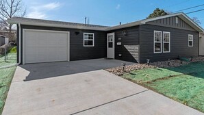 A two-story house with a garage, a front door, and a small front yard with a lawn and a rock bed. - Gazebo-4BR Ping Pong-Arcade Room (Rapid City)