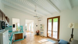 A spacious living area with a kitchen, a dining area, and a large sliding glass door to the outdoors. - Dune Home - Casa con 3 Camere da Letto (Alcamo)