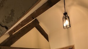 Et soveværelse med en seng, en trædør og en hængende lampe.