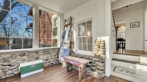 A room with stone walls, wooden flooring, a bench, and a green cooler.