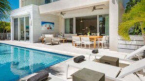 A modern two-story house with a swimming pool, outdoor seating area, and large windows. - Salt Air and Second Wind Villas (Leeward)